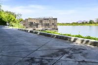 a boat in a lake floating on top of a cement block wall by the edge of the road