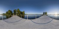 an image of a lake and pier in a panoramic image with lots of sand on it