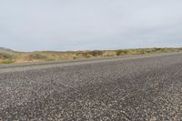 a person walking in a road on the edge of the road with his skateboard