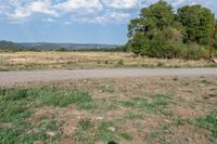 there is a large field and a road next to it with dirt roads leading by