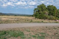 there is a large field and a road next to it with dirt roads leading by