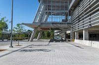 there is a sidewalk in front of a building with columns and windows to let some light into the courtyard