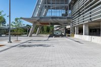 there is a sidewalk in front of a building with columns and windows to let some light into the courtyard