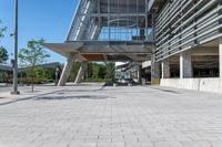 there is a sidewalk in front of a building with columns and windows to let some light into the courtyard