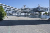 a man walking across a bridge over a river next to some buildings and cars under a bridge