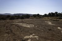 a dirt and mud covered area with a white umbrella in the background for some to see