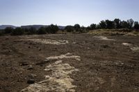 a dirt and mud covered area with a white umbrella in the background for some to see