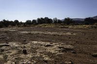 a dirt and mud covered area with a white umbrella in the background for some to see