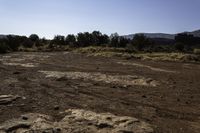 a dirt and mud covered area with a white umbrella in the background for some to see