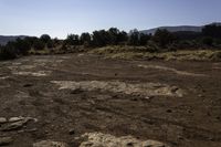 a dirt and mud covered area with a white umbrella in the background for some to see