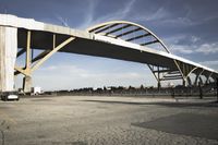 large bridge over parking lot in industrial area next to building with light post on top