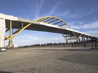 large bridge over parking lot in industrial area next to building with light post on top