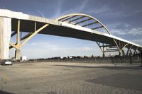 large bridge over parking lot in industrial area next to building with light post on top