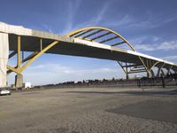 large bridge over parking lot in industrial area next to building with light post on top