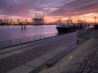 the large container ship is in the dock by the water at sunset as it comes towards the harbor