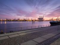 the large container ship is in the dock by the water at sunset as it comes towards the harbor