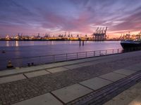 the large container ship is in the dock by the water at sunset as it comes towards the harbor
