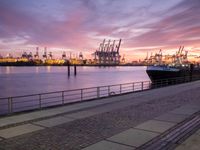 the large container ship is in the dock by the water at sunset as it comes towards the harbor
