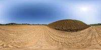 a view of a very large dirt mound in a big field from the bottom to the top of the hill