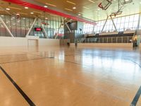 large gymnasium with a wooden basketball court and a goalie goalie net to the side