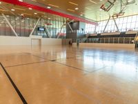 large gymnasium with a wooden basketball court and a goalie goalie net to the side