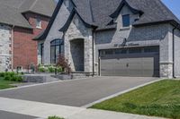 this is an open, large house with grey brick sidings and windows and a white garage