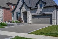 this is an open, large house with grey brick sidings and windows and a white garage