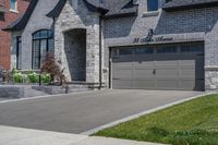 this is an open, large house with grey brick sidings and windows and a white garage