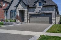 this is an open, large house with grey brick sidings and windows and a white garage