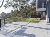 this large patio has a deck overlooking a city and trees from the outside side of it