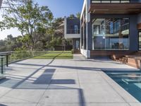 this large patio has a deck overlooking a city and trees from the outside side of it