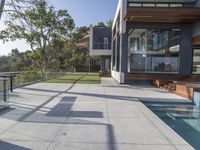 this large patio has a deck overlooking a city and trees from the outside side of it