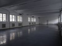 large room with many windows and a radiator in the middle of it and many white ceiling lights