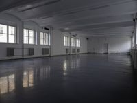 large room with many windows and a radiator in the middle of it and many white ceiling lights