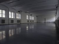 large room with many windows and a radiator in the middle of it and many white ceiling lights