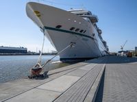 large ship docked in the harbor next to rail tracks and water walkways on the shore