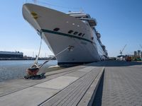 large ship docked in the harbor next to rail tracks and water walkways on the shore