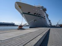 large ship docked in the harbor next to rail tracks and water walkways on the shore