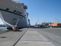 large ship docked in the harbor next to rail tracks and water walkways on the shore