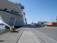 large ship docked in the harbor next to rail tracks and water walkways on the shore