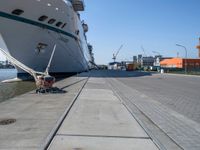 large ship docked in the harbor next to rail tracks and water walkways on the shore