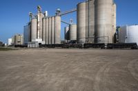 large steel silos in an open field on a sunny day with no people in sight