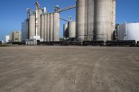 large steel silos in an open field on a sunny day with no people in sight