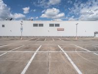 the front of a large warehouse with no parking spots on it's concrete surface