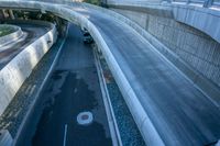 vehicles traveling along the freeway on a bridge above the city streets with skyscrapers and buildings