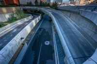 vehicles traveling along the freeway on a bridge above the city streets with skyscrapers and buildings