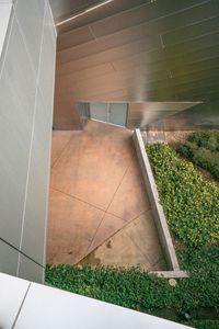 the view of a building from above looking down onto the grass and concrete flooring