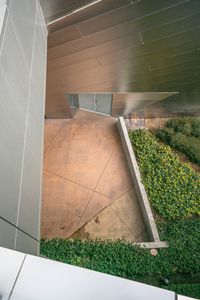 the view of a building from above looking down onto the grass and concrete flooring