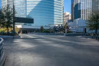 a concrete monument in front of a big skyscraper building in the background with a bike rider in the foreground