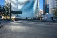 a concrete monument in front of a big skyscraper building in the background with a bike rider in the foreground